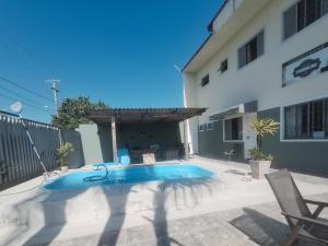 a swimming pool in front of a building at Pousada Recanto Vo da Maria com Piscina a 440mt da praia in Pontal do Paraná +33 photos