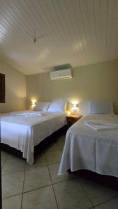 two beds in a hotel room with two lamps at Pousada Velho Chico in Vargem Bonita +124 photos