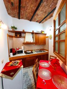 a kitchen with a red table and a red table cloth at Le Antiche Volte suite in Agropoli