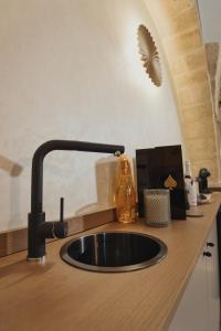 a kitchen sink with a faucet on a counter at Golden Suite in Stornarella