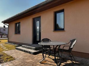 a patio with a table and chairs in front of a house at Dünenhaus Lancken-Granitz in Lancken-Granitz