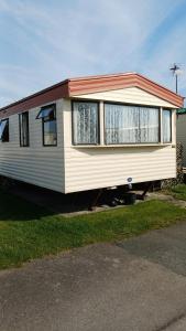a mobile home is parked in a driveway at Bee Happy Caravan in Abergele
