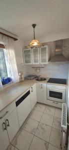 a kitchen with white cabinets and a light fixture at Počitniška hiša Novak in Bohinj