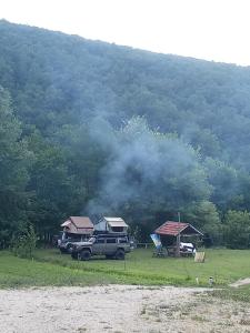 a truck parked in a field next to a mountain at Kamp Suad in Bihać +10 photos