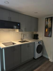 a kitchen with a sink and a washing machine at Joshie Stays in Hamilton