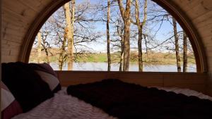 a bed in a room with a large window at Tonneau Bourgignon in Le Rousset