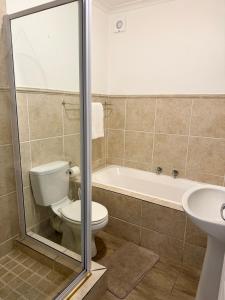 a bathroom with a toilet and a tub and a sink at Luxurious 2Bed ,Iconic Views Mountain& Beach in Big Bay +2 photos