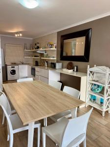 a kitchen with a wooden table and white chairs at Luxurious 2Bed ,Iconic Views Mountain& Beach in Big Bay