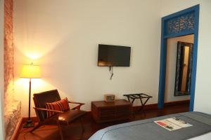 a bedroom with a bed and a tv on the wall at Las Clementinas in Panama City +33 photos