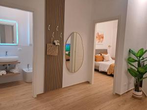 a bathroom with a mirror and a bedroom with a bed at Lo Spaho Suite Florence in Florence