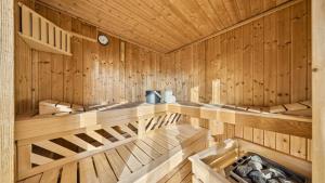 a wooden sauna with benches and a clock at Suite4you Erlen l Privater Indoorpool ganzjährig beheizt & Sauna l 10min zum Bodensee, Parkplatz & WLAN in Erlen