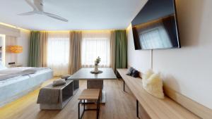a bedroom with a bed and a table and a couch at Boutique Hotel Adler in Golling an der Salzach