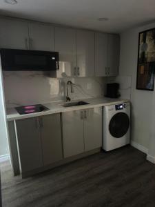 a kitchen with a sink and a washing machine at Joshie Stays in Hamilton