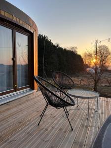 a patio with a table and chairs on a deck at Jurta Jura leśna in Przybysławice