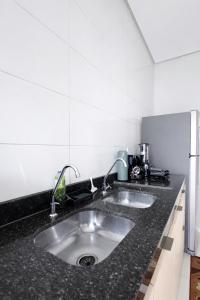 a kitchen with a stainless steel sink and black counter top at Casa 3 Quartos , Ar Condicionado e Área de Churrasco com Ducha in Juazeiro