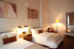 a hotel room with two beds and a lamp at Las Clementinas in Panama City