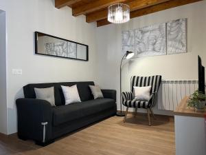 a living room with a black couch and a chair at Apartamentos Miguel 2 in Onís