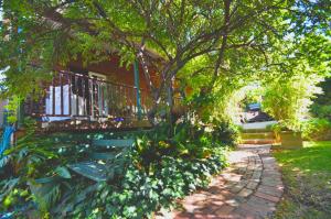 un jardin avec un banc, un arbre et une maison dans l'établissement RoseMoore Bed & Breakfast, à Perth