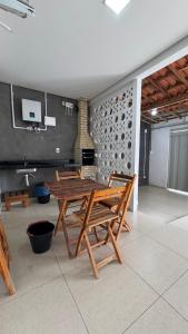 a wooden table and chairs in a room with a fireplace at Casa 3 Quartos , Ar Condicionado e Área de Churrasco com Ducha in Juazeiro +21 photos