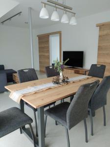 a dining room with a wooden table and chairs at Ferienwohnung Hagebutte in Bad Bocklet