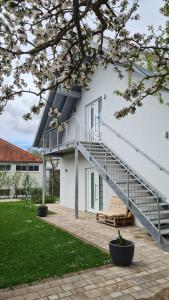 a white house with a staircase and a bench at Ferienwohnung Hagebutte in Bad Bocklet
