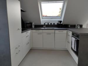 a white kitchen with a sink and a window at Ferienwohnung Hagebutte in Bad Bocklet