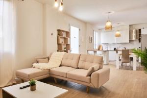a living room with a couch and a kitchen at Ortensie House in Padova