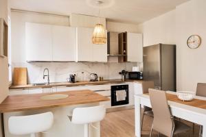 a kitchen with white cabinets and a wooden table at Ortensie House in Padova