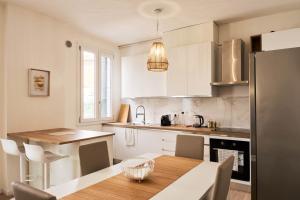 a kitchen with white cabinets and a wooden table at Ortensie House in Padova