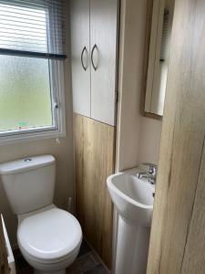 a bathroom with a toilet and a sink at Caravan Holiday Park in Newquay in Newquay +17 photos