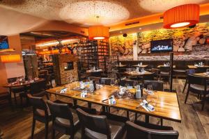 a restaurant with a large wooden table and chairs at Boutique Hotel Adler in Golling an der Salzach