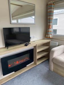 a living room with a tv and a fireplace at Caravan Holiday Park in Newquay in Newquay