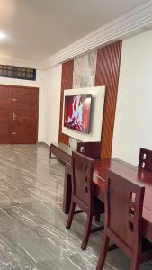 a room with a table and chairs and a television at Maison Sika in Zogbégan
