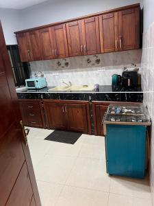a kitchen with wooden cabinets and a blue stove at Maison Sika in Zogbégan