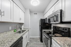 a kitchen with white cabinets and a black stove at Great 1BR Mid-Term Apartment in Denton