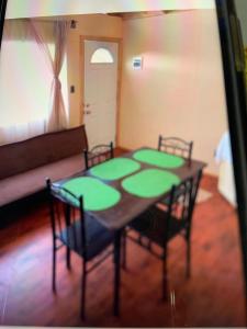 a room with a table with four chairs and a couch at Cabañas río seco in Punta Arenas +3 photos
