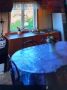 a table and chairs in a kitchen with a window at Cabañas río seco in Punta Arenas