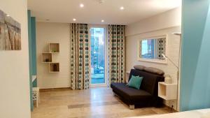 uma sala de estar com um sofá e uma janela em Bed aan zee Kabine7 em Koksijde