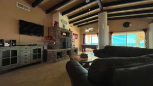 a living room with a couch and a stone fireplace at Recently Updated Beachfront Home Casa Neblina in Puerto Peñasco