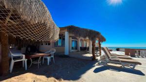a house on the beach with chairs and a table at Recently Updated Beachfront Home Casa Neblina in Puerto Peñasco +20 photos