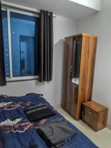 a bedroom with a bed and a tv and a window at Rahatani pimple Saudagar 2bhk in Chinchwad
