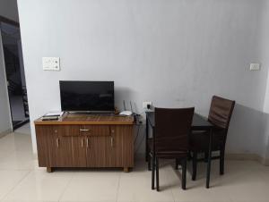 a table with chairs and a desk with a laptop on it at Rahatani pimple Saudagar 2bhk in Chinchwad