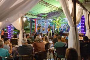 a group of people sitting in chairs watching a band on a stage at Itá Thermas Resort e Spa in Itá +232 photos