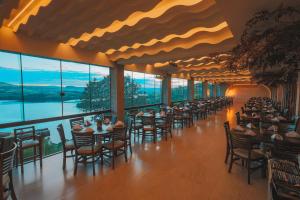 a banquet hall with tables and chairs and windows at Itá Thermas Resort e Spa in Itá