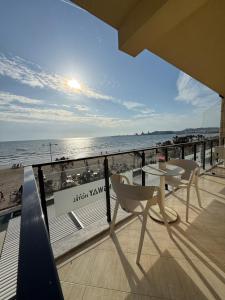a balcony with a table and chairs on the beach at Heming-way Hotel in Durrës