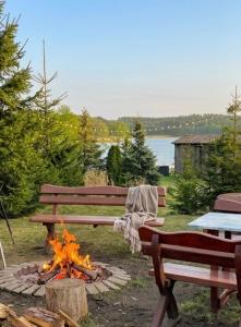 a fire pit with a bench and a picnic table at Agro nad jeziorem in Miastko