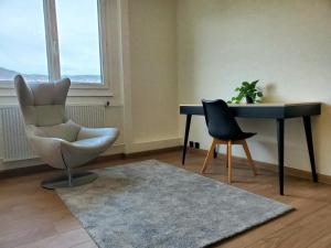 a living room with a desk and a chair and a table at Le Cocon Clermontois - T2 Centre in Clermont-Ferrand