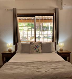 a bedroom with a large bed with a window at Villa Maria Anse Corail in Takamaka
