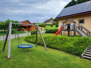 a playground with a swing set and a slide at Pauza Plac in Žitence