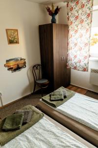 a bedroom with two beds and a chair and a window at Berlin Home by RentALL in Gheorgheni